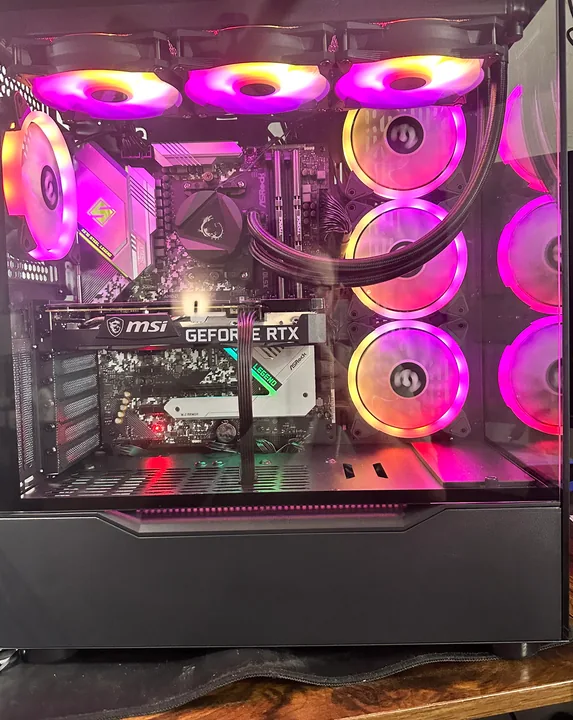 Black desktop PC with magenta-lit fans and liquid-cooling tubes