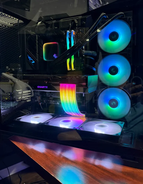 Desktop PC interior with blue-lit fans and an illuminated rainbow cable extension