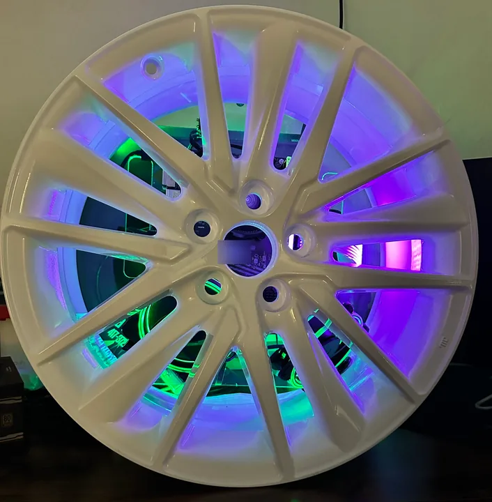 White wheel-style PC enclosure with purple and green lighting inside